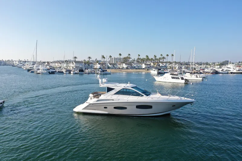 Slide: The Image of 2015 Regal 53 Sport Coupe yacht cruising in a scenic marina. - 6