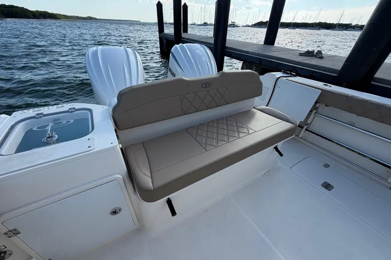 Slide: The Image of 2009 Pursuit OS 315 Offshore boat interior with cushioned seating and twin engines. - 13