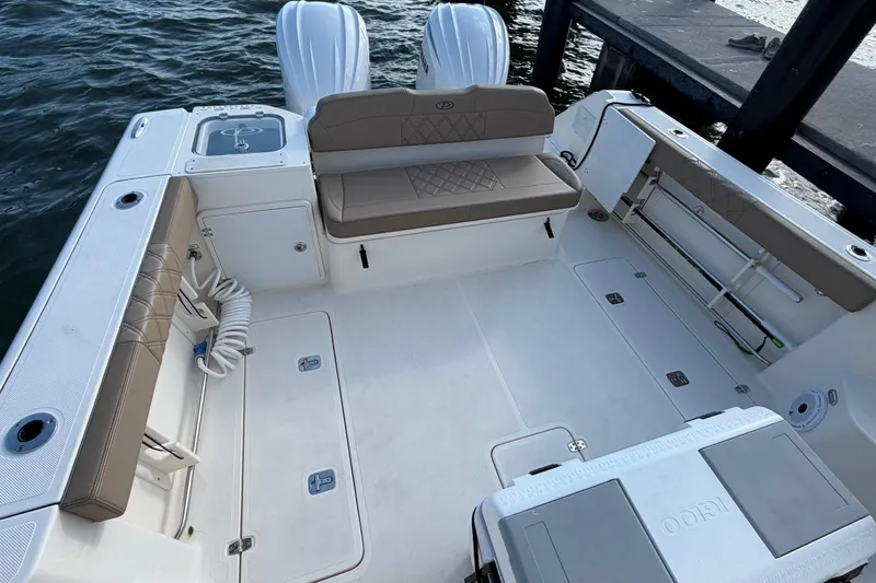 Slide: The Image of 2009 Pursuit OS 315 Offshore boat deck with seating and storage, docked by the water. - 14