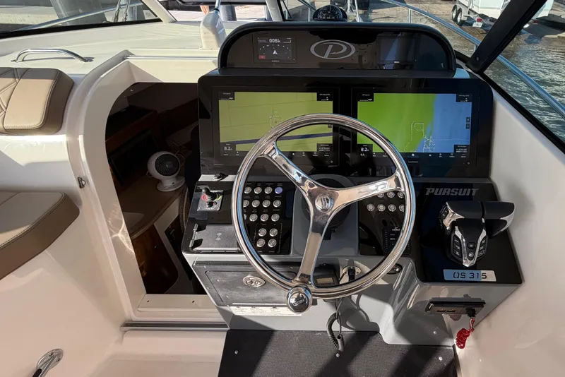 Slide: The Image of Helm of 2009 Pursuit OS 315 Offshore boat with navigation screens and controls. - 19