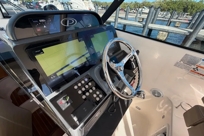 Slide: The Image of 2009 Pursuit OS 315 Offshore helm with modern navigation displays and steering wheel. - 20