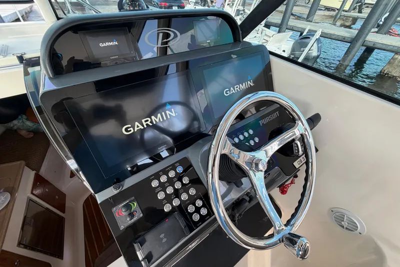 Slide: The Image of 2009 Pursuit OS 315 Offshore helm with Garmin displays and chrome steering wheel. - 21