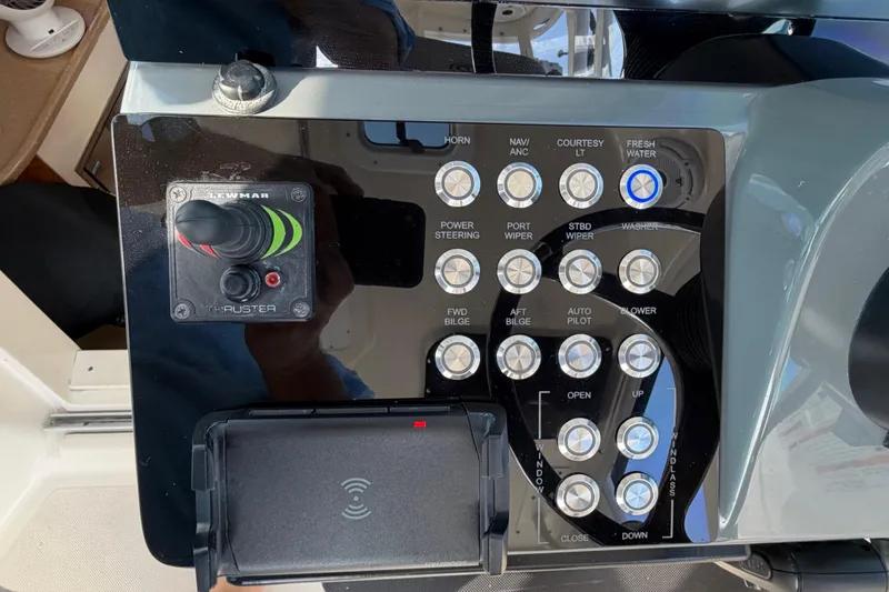 Slide: The Image of Control panel of a 2009 Pursuit OS 315 Offshore boat with various switches and a thruster joystick. - 22