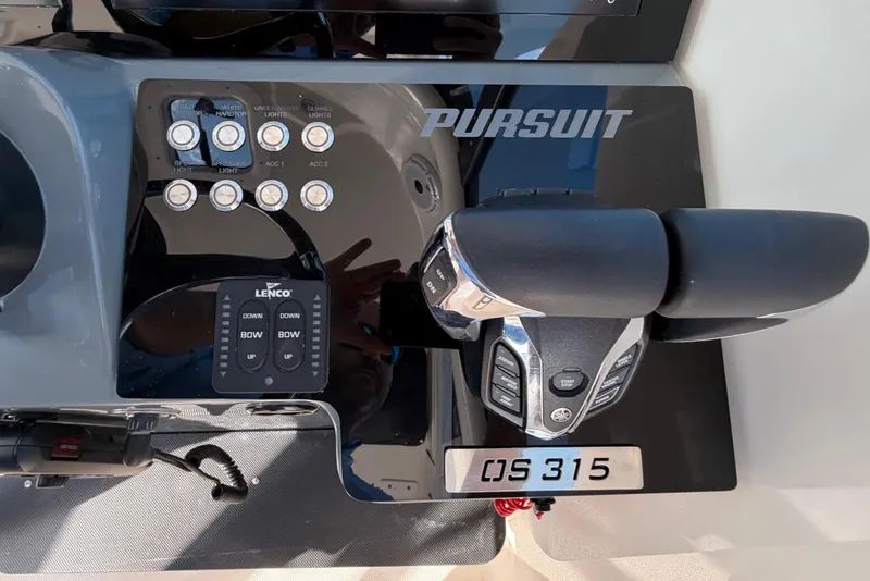 Slide: The Image of Control panel of a 2009 Pursuit OS 315 Offshore boat with throttle and switches. - 23