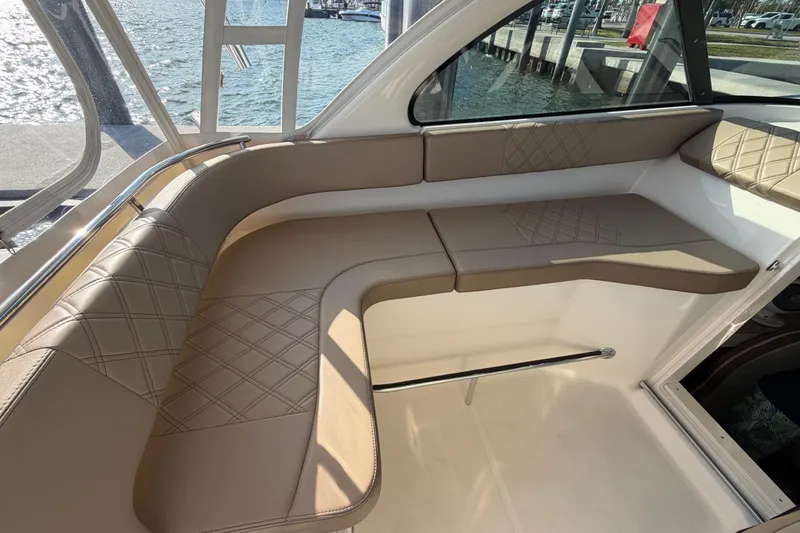 Slide: The Image of Luxurious seating area on a 2009 Pursuit OS 315 Offshore boat, featuring diamond-stitched upholstery. - 27
