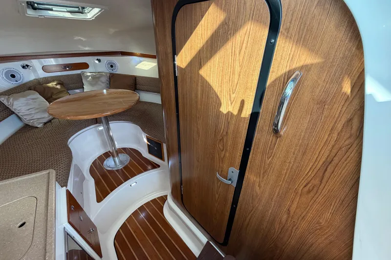 Slide: The Image of 2009 Pursuit OS 315 Offshore cabin interior with wood accents and cozy seating area. - 30
