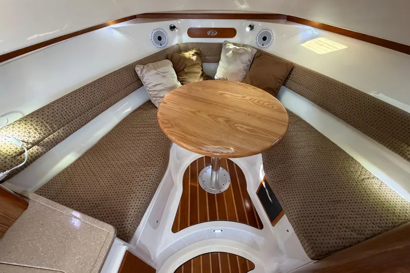 Slide: The Image of 2009 Pursuit OS 315 Offshore cabin interior with cozy seating and wooden table. - 31