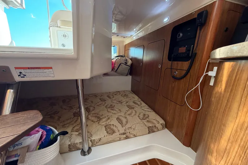 Slide: The Image of 2009 Pursuit OS 315 Offshore cabin interior with wood paneling and cushioned seating. - 35