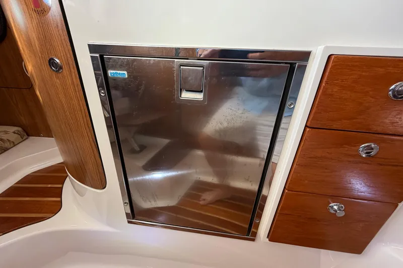 Slide: The Image of 2009 Pursuit OS 315 Offshore interior with stainless steel fridge and wooden cabinetry. - 36
