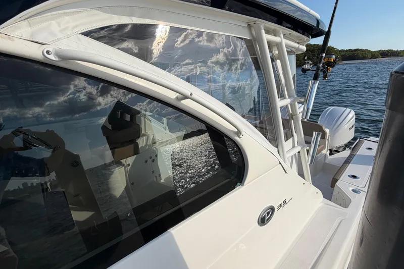 Slide: The Image of 2009 Pursuit OS 315 Offshore boat on water, reflecting sky and clouds. - 42