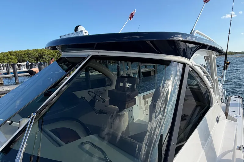 Slide: The Image of 2009 Pursuit OS 315 Offshore boat docked, showcasing sleek design and spacious cockpit. - 43