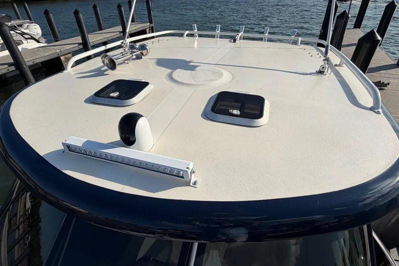 Slide: The Image of 2009 Pursuit OS 315 Offshore boat deck with hatches and railing at dockside. - 45