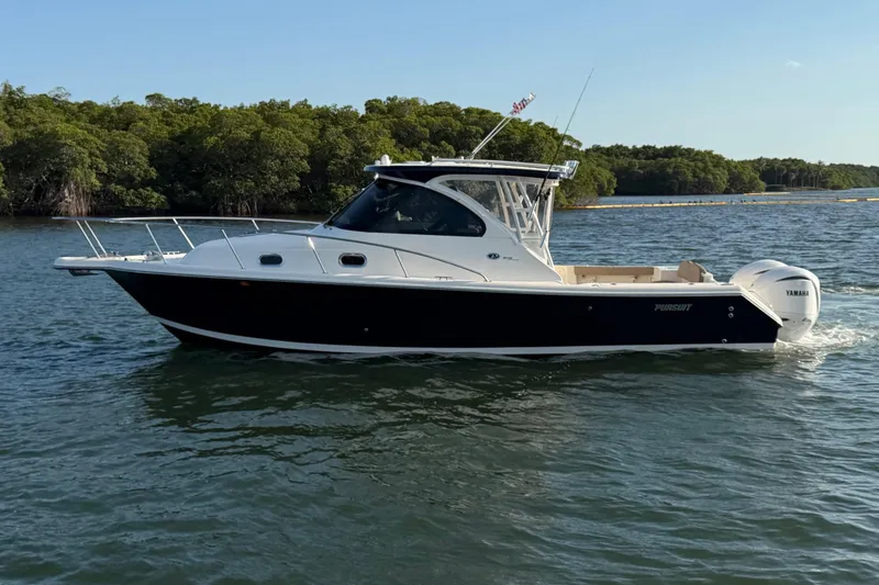 Slide: The Image of 2009 Pursuit OS 315 Offshore boat cruising on a calm lake near lush greenery. - 5