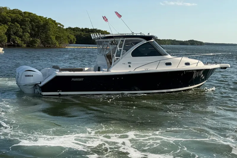 Slide: The Image of 2009 Pursuit OS 315 Offshore boat on water with Yamaha engines, scenic background. - 6