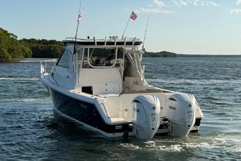 Slide: The Image of 2009 Pursuit OS 315 Offshore boat with twin Yamaha engines on the water. - 7