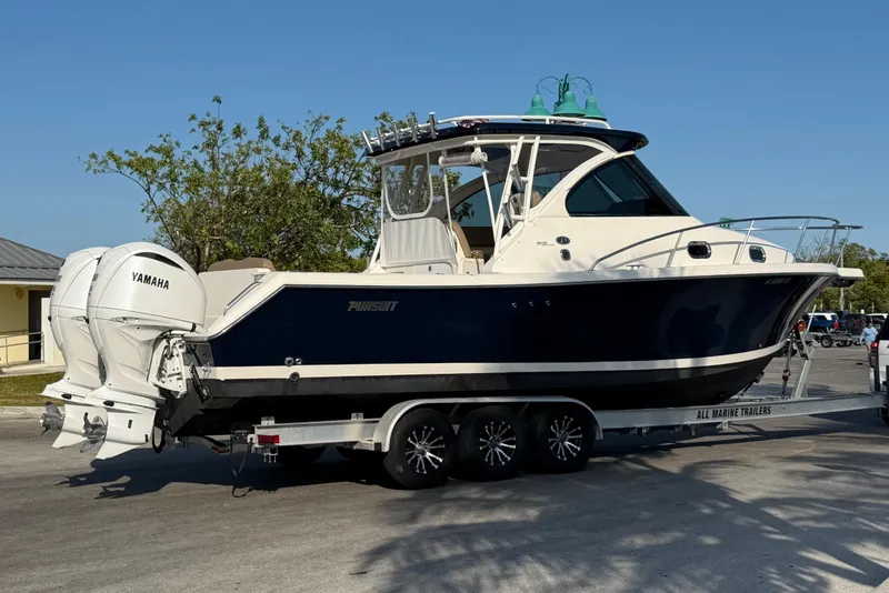 Slide: The Image of 2009 Pursuit OS 315 Offshore boat on trailer with Yamaha engines, parked outdoors. - 8