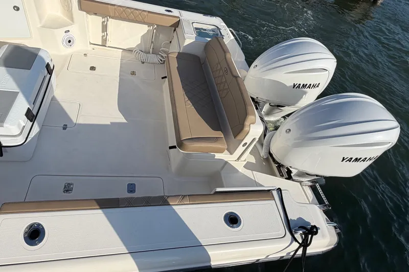 Slide: The Image of 2009 Pursuit OS 315 Offshore boat with Yamaha outboard engines, featuring spacious deck seating. - 9