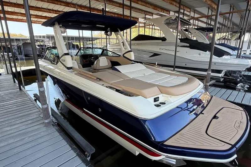 Slide: The Image of 2026 Chris-Craft Sportster 28 luxury boat docked in marina, showcasing sleek design and spacious seating. - 4
