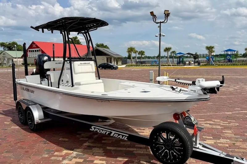 The Image of 2022 Blazer Bay 2200 boat on trailer, parked on brick pavement under cloudy sky. - 1