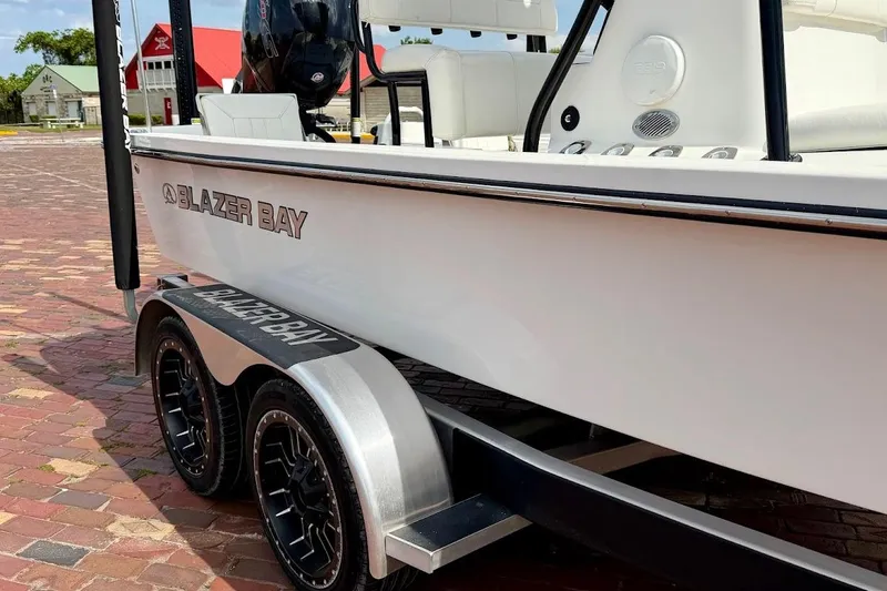 Slide: The Image of 2022 Blazer Bay 2200 boat on trailer, parked on brick pavement. - 10
