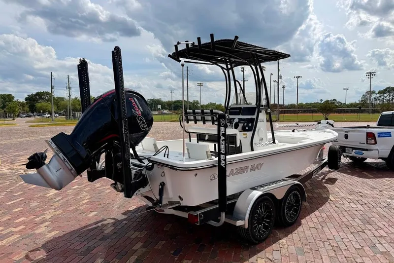Slide: The Image of 2022 Blazer Bay 2200 boat on trailer, parked outdoors under cloudy sky. - 4