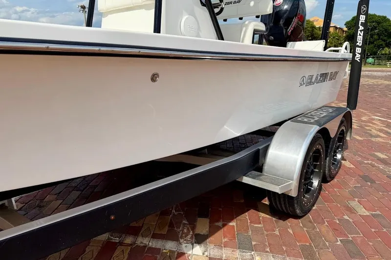 Slide: The Image of 2022 Blazer Bay 2200 boat on trailer, parked on brick pavement. - 6