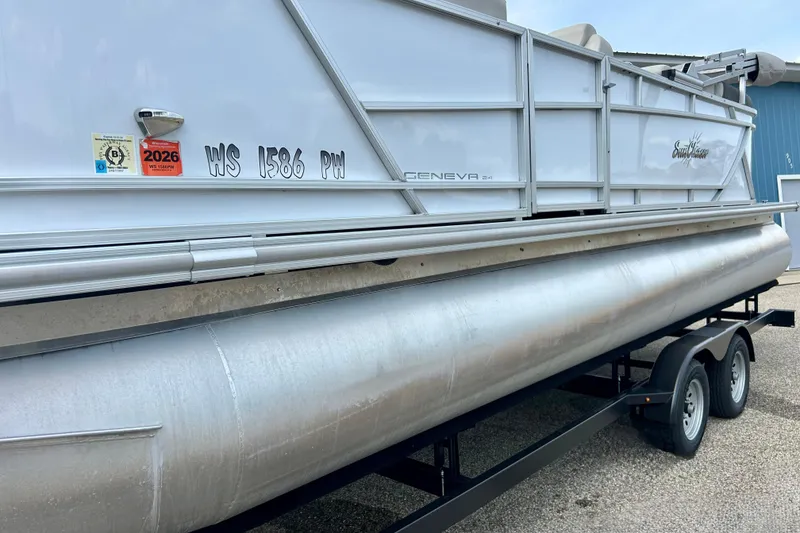 Slide: The Image of 2023 Sun Chaser Geneva pontoon boat on trailer, displaying registration and inspection stickers. - 19