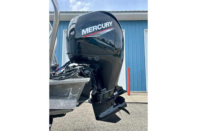 Slide: The Image of 2023 Sun Chaser Geneva boat with Mercury outboard motor, parked near blue building. - 23