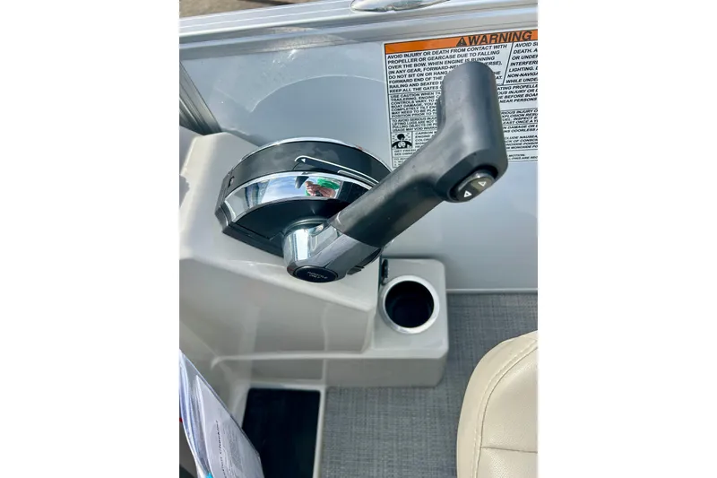 Slide: The Image of Throttle control lever on 2023 Sun Chaser Geneva boat, with warning label and cup holder. - 40