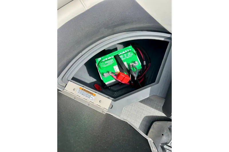 Slide: The Image of Battery compartment of 2023 Sun Chaser Geneva boat, featuring a secured green battery. - 46