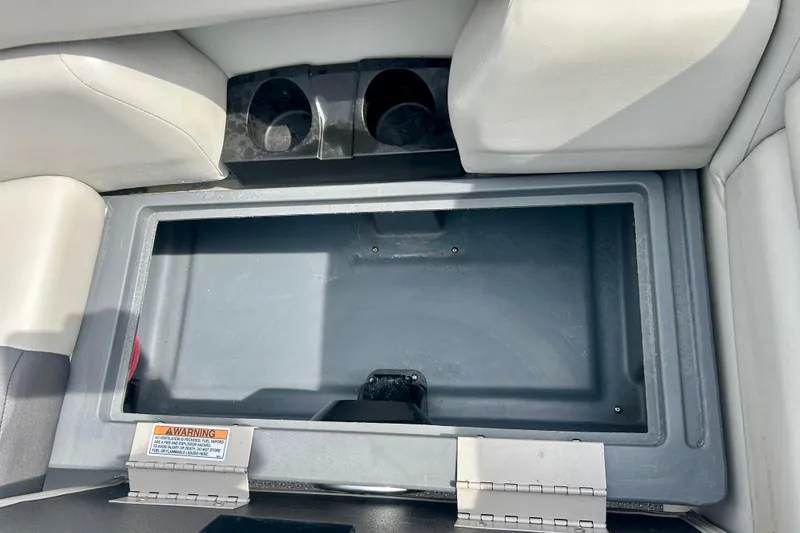 Slide: The Image of Storage compartment in 2023 Sun Chaser Geneva boat with cup holders and warning label. - 48
