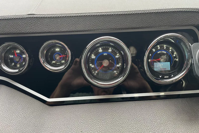 Slide: The Image of Dashboard gauges of a 2016 Sea Ray SLX 230 boat, featuring speedometer and RPM indicators. - 16