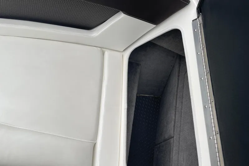 Slide: The Image of Interior view of 2016 Sea Ray SLX 230 boat, featuring white upholstery and storage compartment. - 17