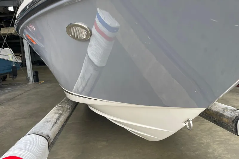 Slide: The Image of 2016 Sea Ray SLX 230 boat hull in storage, showcasing sleek design and glossy finish. - 24