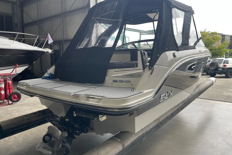Slide: The Image of 2016 Sea Ray SLX 230 boat in a storage facility, featuring a covered cockpit. - 7