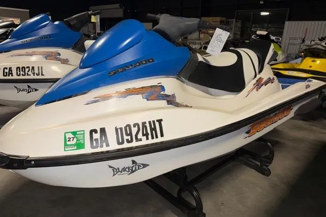 Slide: The Image of 2004 Sea-Doo GTI RFI jet ski with blue and white design in showroom. - 3