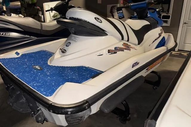 Slide: The Image of 2004 Sea-Doo GTI RFI jet ski with blue accents in a garage setting. - 6