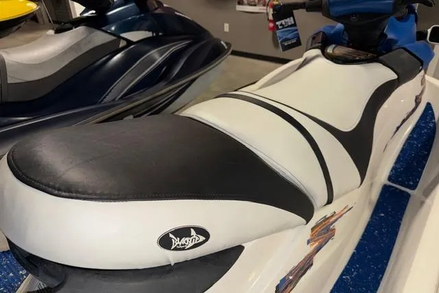 Slide: The Image of 2004 Sea-Doo GTI RFI jet ski with black and white seat in showroom. - 7