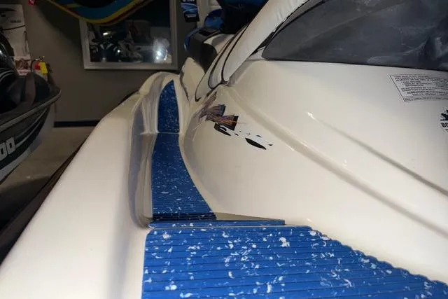 Slide: The Image of 2004 Sea-Doo GTI RFI jet ski with blue footrests in a garage setting. - 8