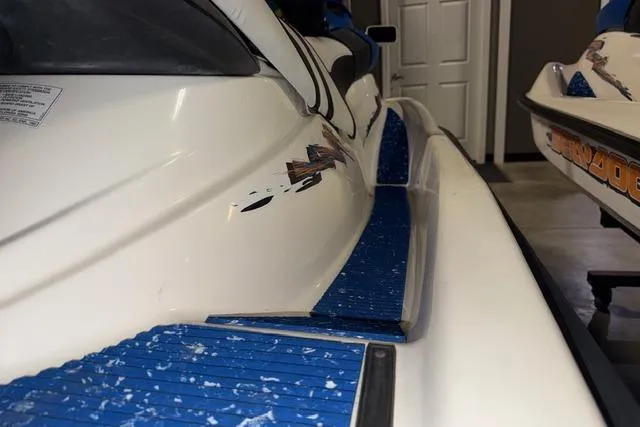 Slide: The Image of 2004 Sea-Doo GTI RFI jet ski with blue footrests in a garage setting. - 9