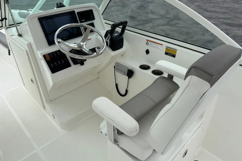 Slide: The Image of Helm of 2020 World Cat 230 DC boat with steering wheel and control panel. - 11