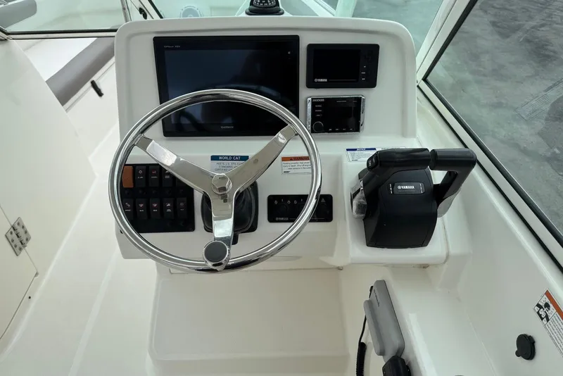 Slide: The Image of 2020 World Cat 230 DC helm with steering wheel, Yamaha controls, and Garmin display. - 12