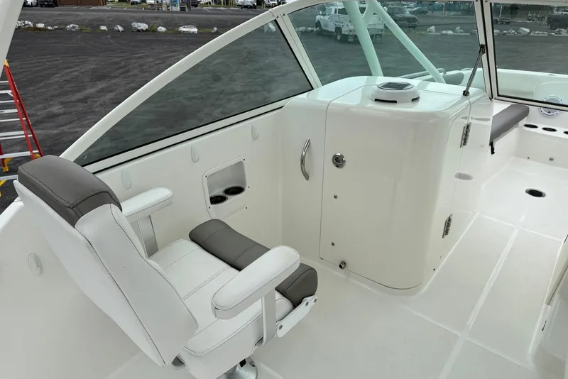 Slide: The Image of 2020 World Cat 230 DC boat interior with white seating and storage compartments. - 13