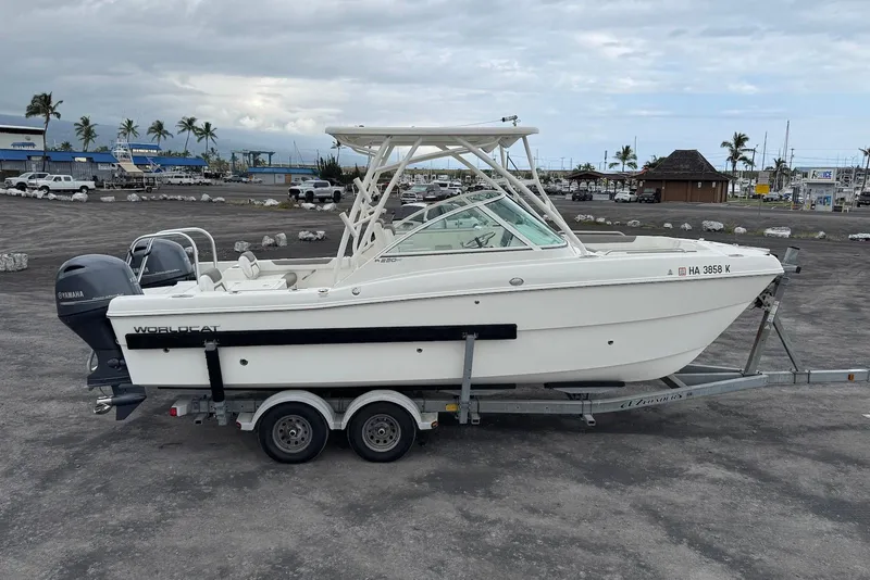 Slide: The Image of 2020 World Cat 230 DC boat on trailer, parked in a marina setting. - 6