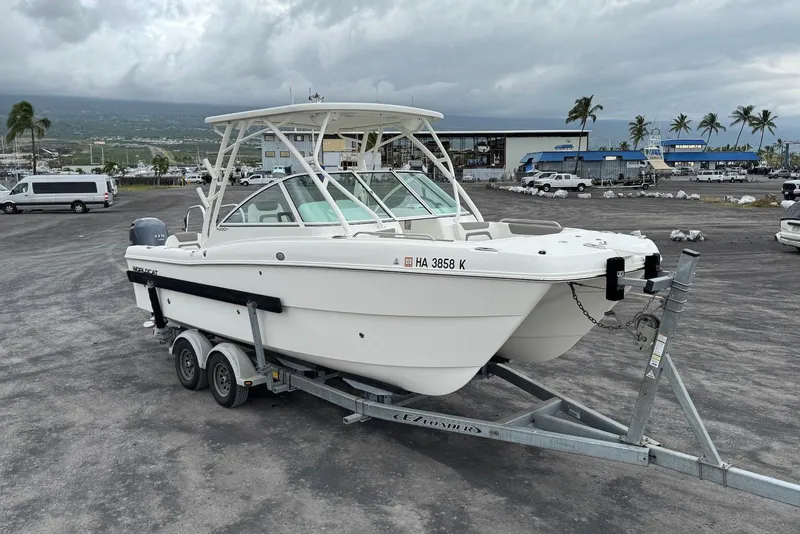 Slide: The Image of 2020 World Cat 230 DC boat on trailer in a marina parking lot. - 7