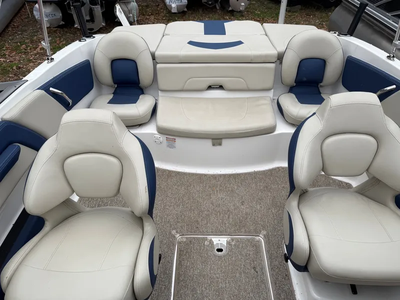 Slide: The Image of Interior of a 2014 Chaparral 210 boat with beige and blue seating. - 8