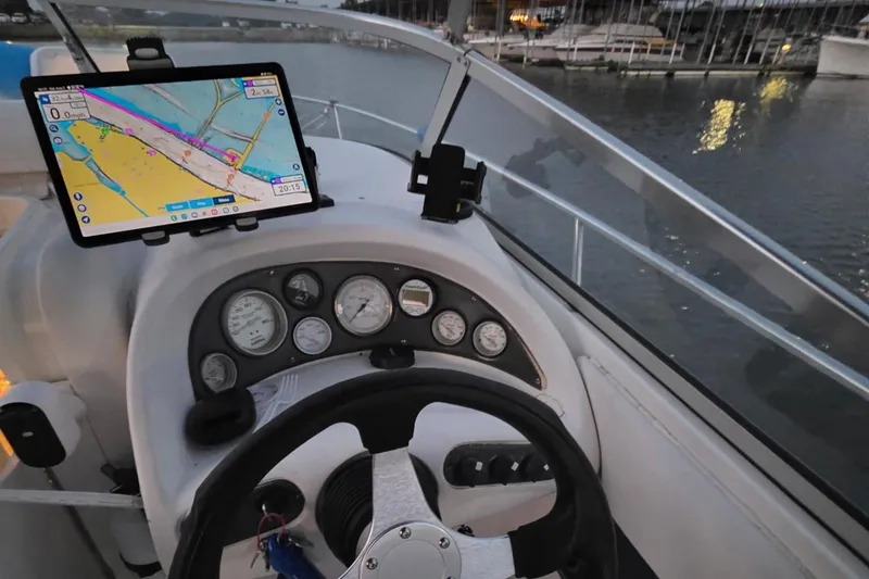 Slide: The Image of 2001 Glastron GS 249 boat dashboard with navigation screen, steering wheel, and gauges. - 18