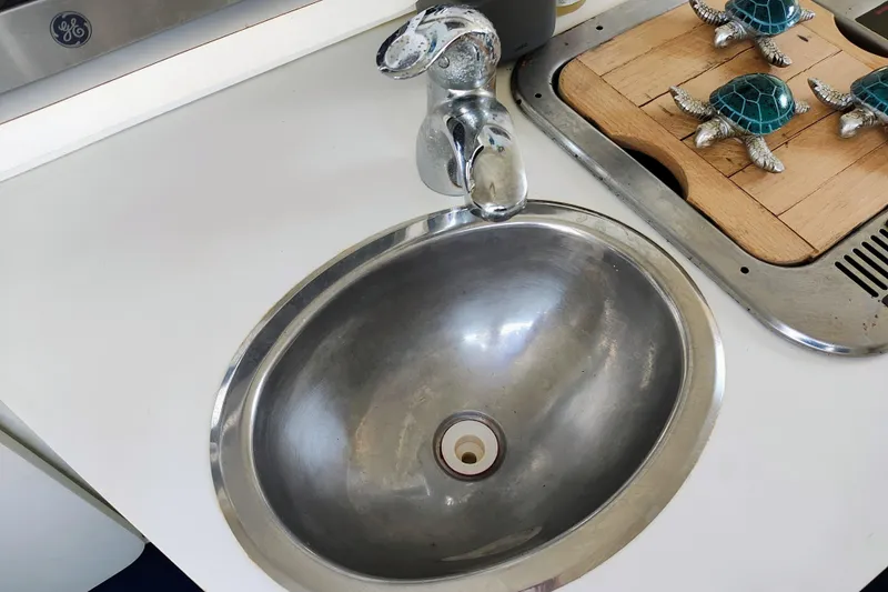 Slide: The Image of Stainless steel sink on 2001 Glastron GS 249 boat with decorative turtle figurines nearby. - 27