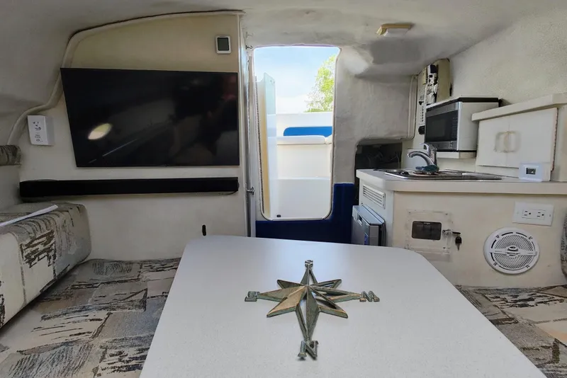 Slide: The Image of Interior of a 2001 Glastron GS 249 boat with kitchenette and seating area. - 32
