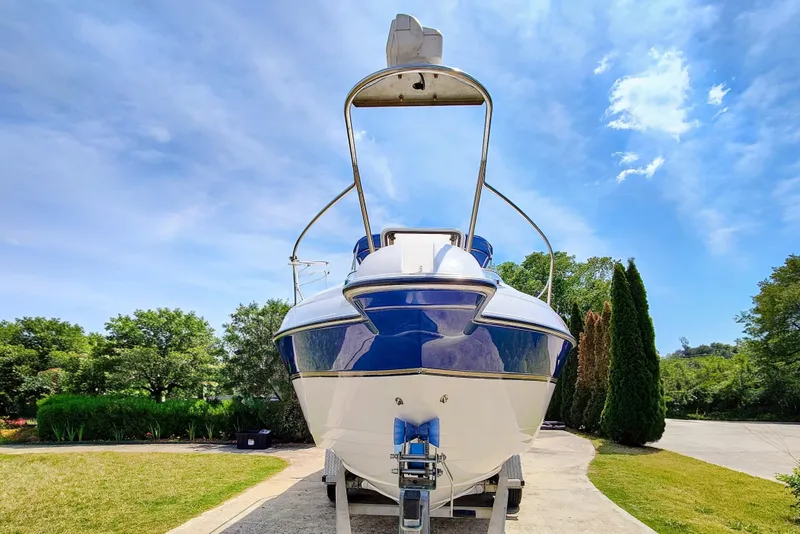 Slide: The Image of 2001 Glastron GS 249 boat on trailer, parked outdoors under a clear blue sky. - 4